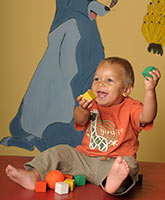 Ein Kind spielt glücklich im Wartezimmer mit Würfeln.